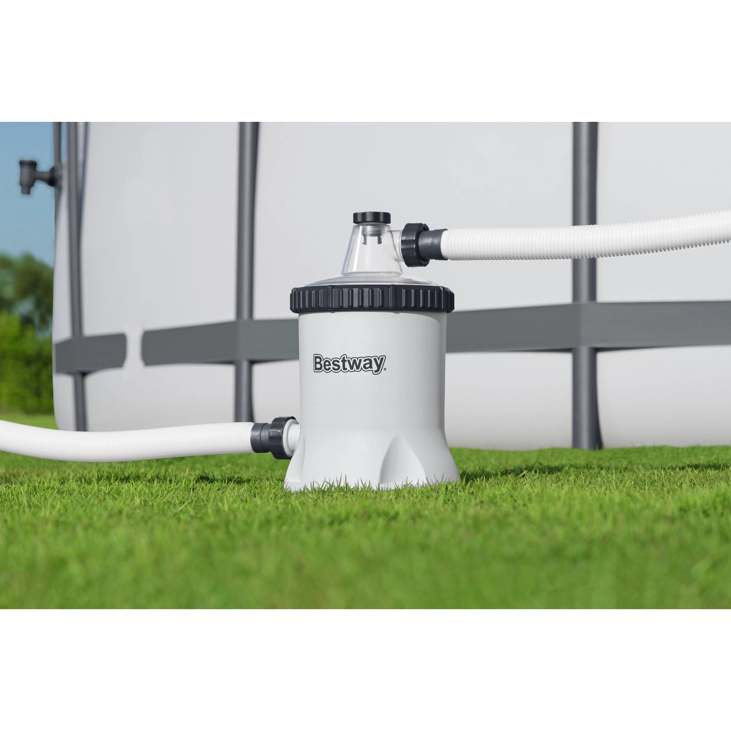Weiße Bestway Polysphere Filterpumpe mit Schläuchen am Pool auf grünem Rasen. Reinigt Poolwasser effizient.
