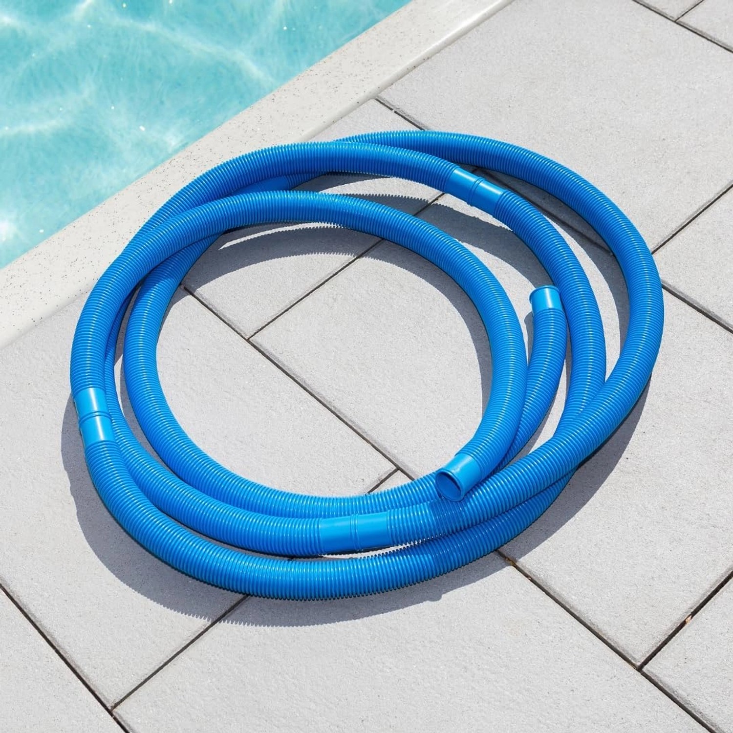 Blauer poolomio Poolschlauch (9,9m) mit Trennmuffen am Poolrand.