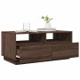 Moderner Couchtisch in Braun Eichen-Optik mit offenen Fächern, geöffneter Schublade und LED-Beleuchtung.