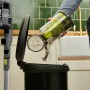 Ryobi Akku-Staubsauger RSVS18-0 One+ beim Entleeren des Staubbehälters in einen Mülleimer.