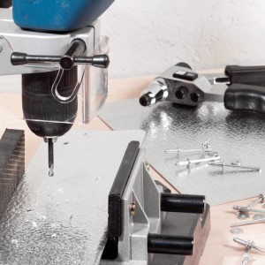 LUX Nieten-Bohrer 2,5 mm im Einsatz mit Nietenzange und Werkstücken.