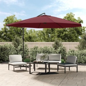Bordeauxroter Ampelschirm mit Metallmast, geöffnet über einer Terrasse mit Sitzgruppe, spendet Schatten.