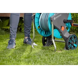 Gardena Schlauchwagen CleverRoll M mit 20m Schlauch auf Rasen. Gartenschlauchwagen-Set in Türkis und Grau.