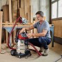 Einhell TE-VC 2025 SACL Nass-Trockensauger im Einsatz in Werkstatt mit Mann.