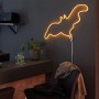 Orangefarbener LED-Streifen in Form einer Fledermaus als Deko-Element im Raum.