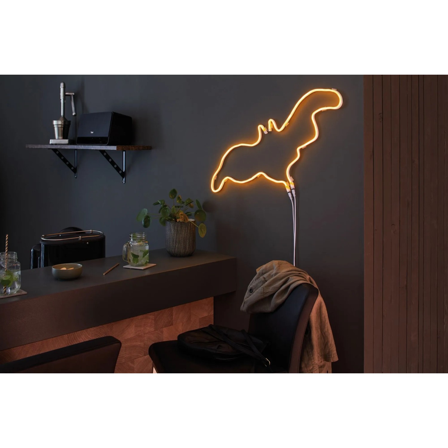 Orangefarbener LED-Streifen in Form einer Fledermaus als Deko-Element im Raum.