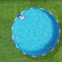Rundes Schwimmbecken auf Primaflor Kunstrasen Arizona Grün, mit Person im Wasser.