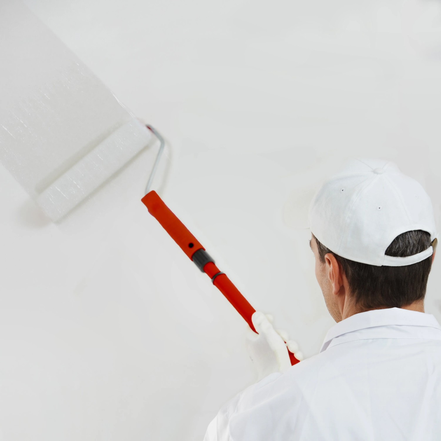 Mann streicht Wand mit Farbroller und Stegu Grundierung. Haftgrund für Innen & Außen, 5 l.