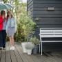Philips myGarden Bustan LED-Außenwandleuchte mit Bewegungsmelder an dunkler Holzwand.