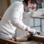 Frau schleift Holz mit Bosch Expert Schleifschwamm. Schleifmittel für Holz und Farbe.