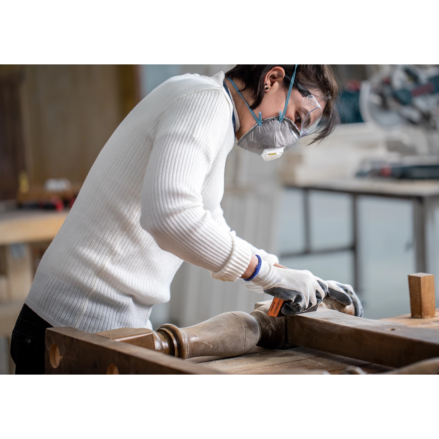 Frau schleift Holz mit Bosch Expert Schleifschwamm. Schleifmittel für Holz und Farbe.