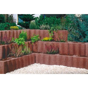 Beispiel einer Hangbefestigung mit braunen Wellino Pflanzsteinen (30x20x20 cm), bepflanzt mit diversen Pflanzen.