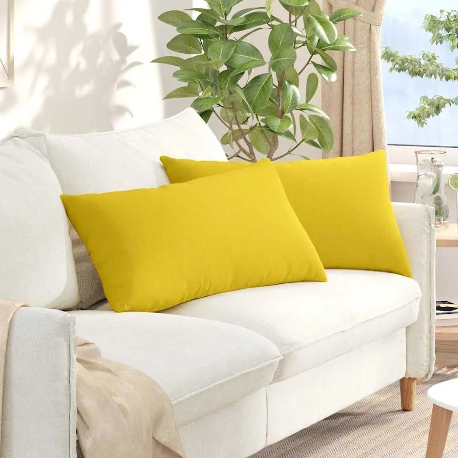 Zwei rechteckige Sofakissen in hellem Gelb aus Stoff auf einem weißen Sofa. Ideal für Wohnzimmer, 80x40 cm.