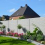 Graue Betonzaun-Platte Fels (200x38,5x3 cm) als Sichtschutz im Garten mit Blumen und Rasen.