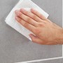Hand reinigt graue Fliese mit fischer Klebepads Vakuum Pad. Vielseitig einsetzbar.