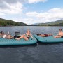 Bestway Hydro Force Floating Platform Sun Soaker: Zwei verbundene, türkisblaue Wasserplattformen mit Personen auf einem See.