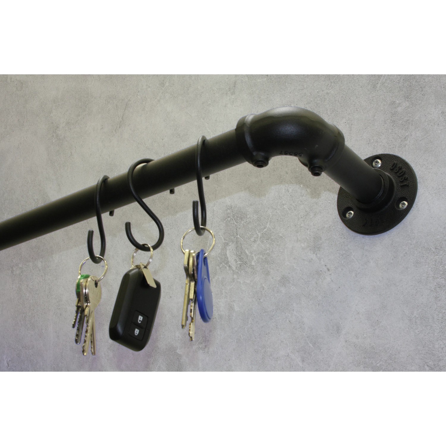 Gardinia Eckstück Industrial Home, Ø 25 mm, schwarz, an Wand montiert mit Schlüsseln an Haken.
