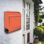 Orangefarbener Banjado Edelstahl Briefkasten mit Zeitungsfach an weißer Hauswand.