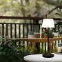 Schwarze LED Solar Tischleuchte Emmi (Ø 13cm) auf Gartentisch. Dimmbare Solar-Deko für Außen.