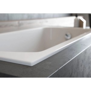 Weiße rechteckige Acryl-Badewanne KOLMAN 155x70 cm mit Ablauf, elegant in dunkle Oberfläche integriert.