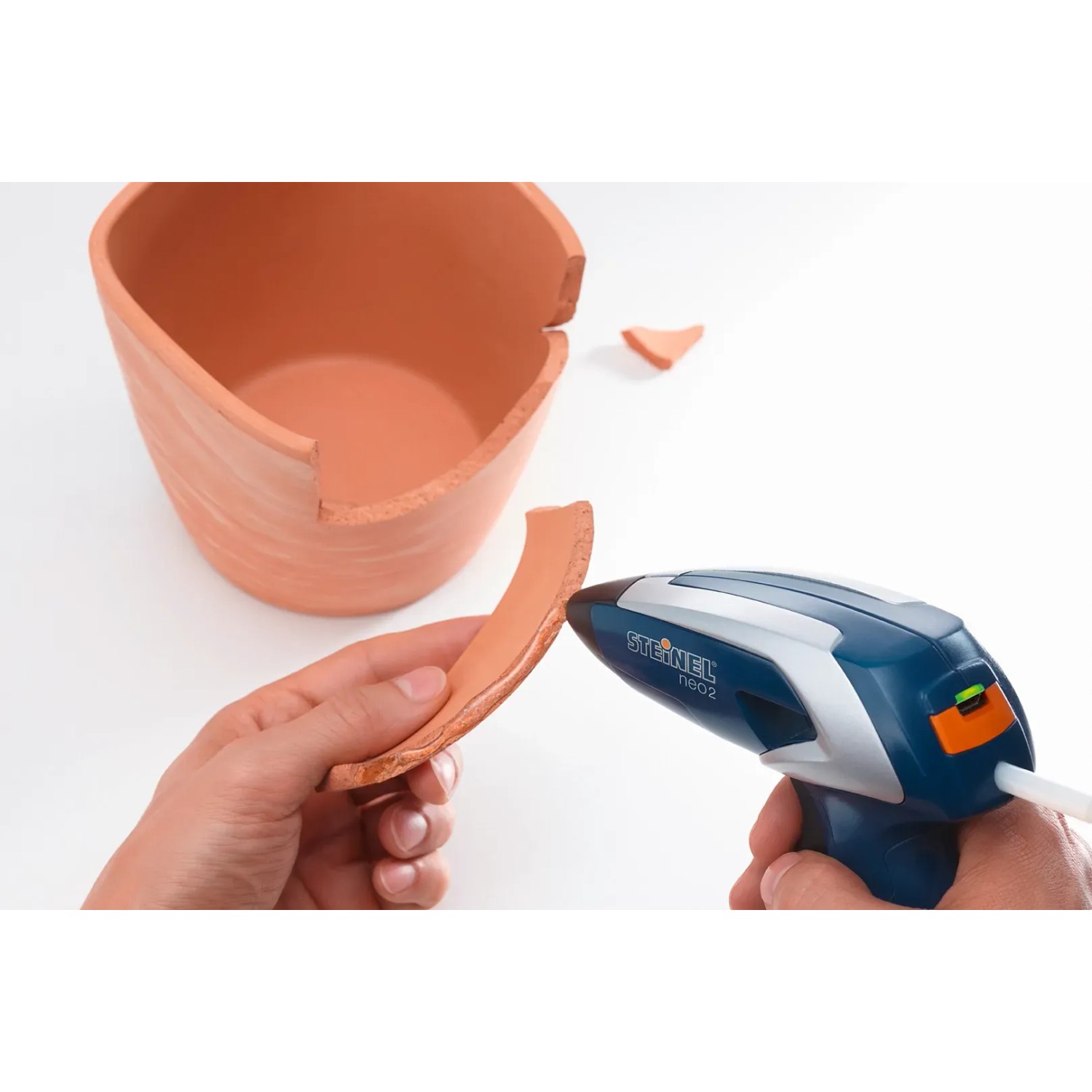 Steinel Akku-Heißklebepistole Neo 2 beim Kleben eines zerbrochenen Blumentopfs.