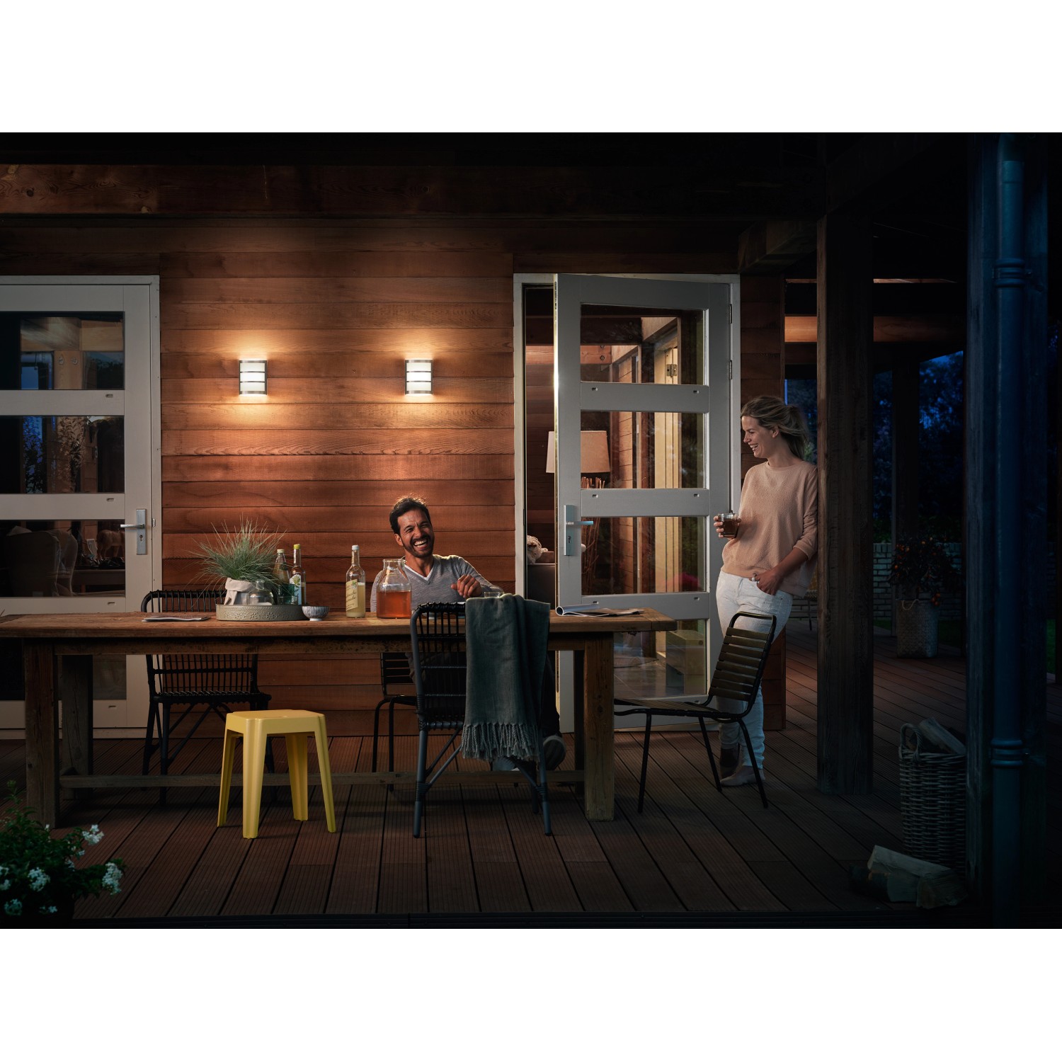 Szene mit Philips LED-Außenwandleuchte Python Edelstahl an Holzhauswand.