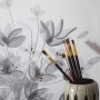 Schöner Wohnen Fototapete Floral Grau-Beige mit Pinsel im Topf vor der Tapete.