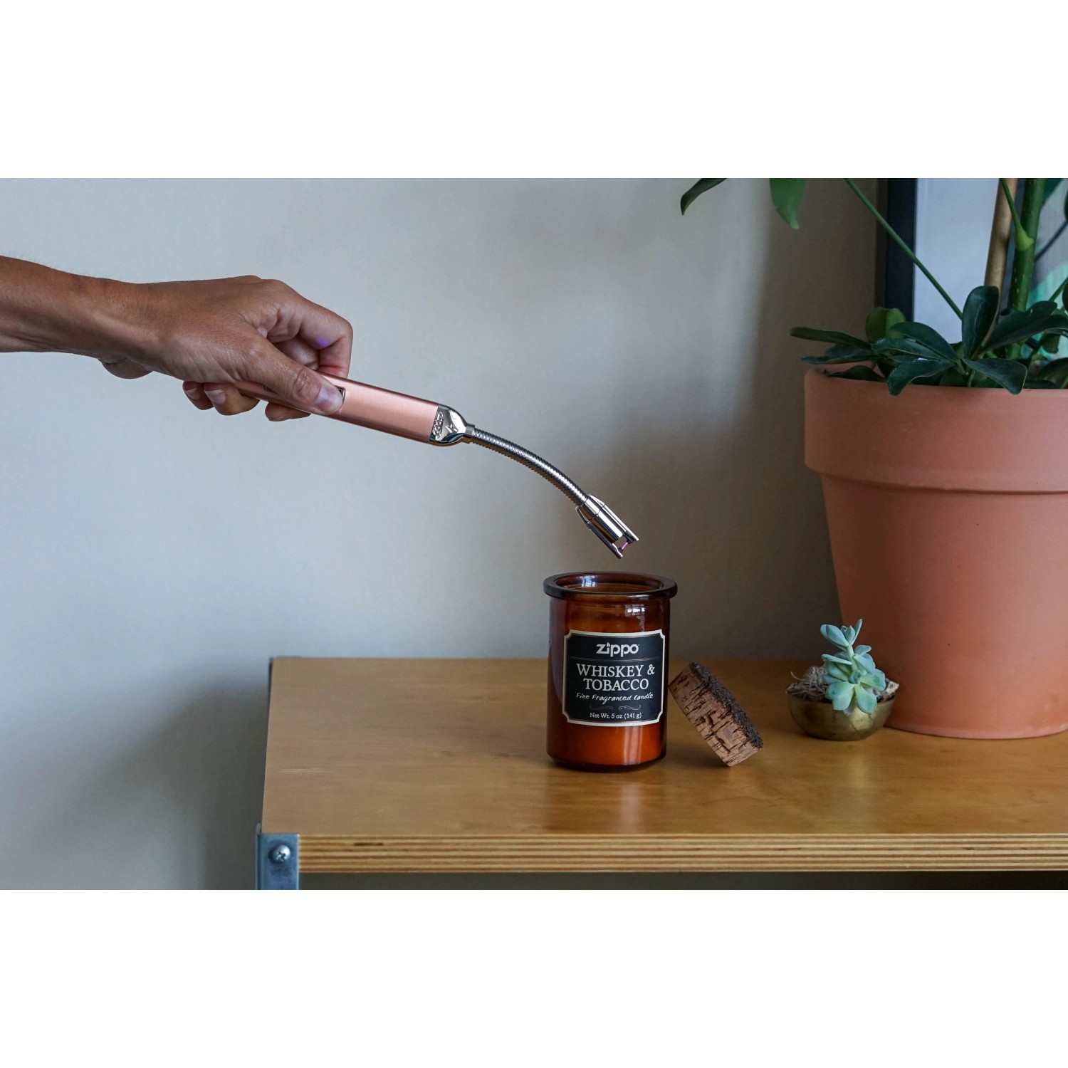 Zippo Kerzenfeuerzeug Rose Gold mit Schwanenhals beim Anzünden einer Kerze.