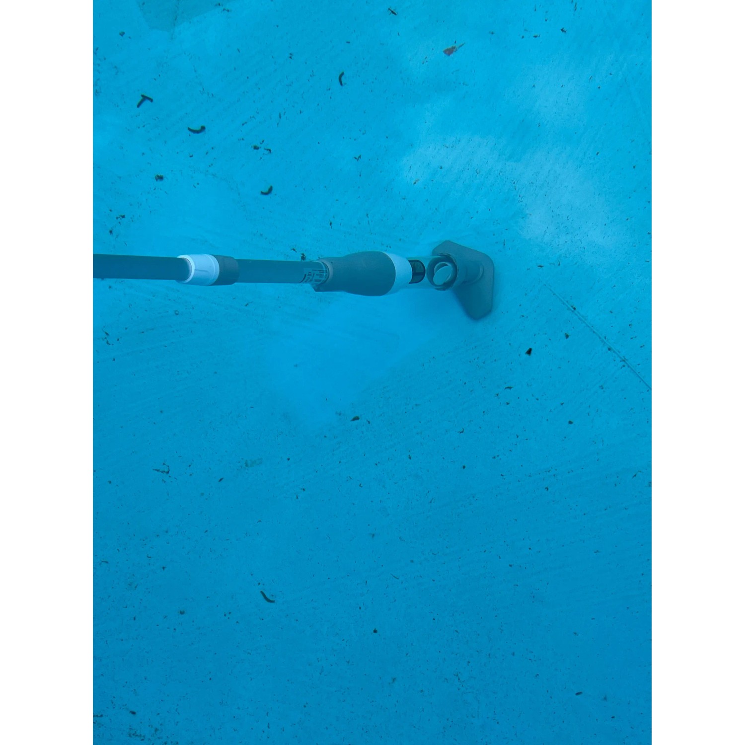 Pool-Handsauger im Einsatz unter Wasser. Kabelloser Poolsauger mit Teleskopstange.