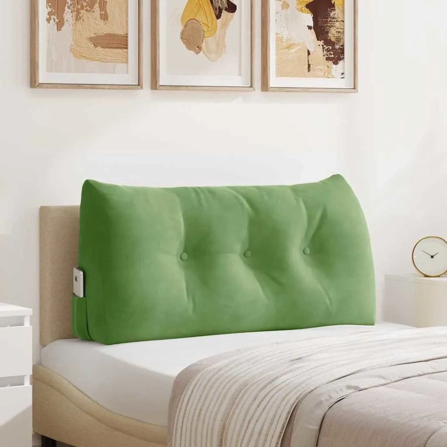 Hellgrünes Samt-Rückenkissen mit Knöpfen und Seitentasche auf einem Bett. Bietet Komfort und Unterstützung.