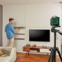 Bosch UniversalLevel 360 Kreuzlinienlaser im Einsatz mit Stativ und grünen Laserlinien beim Regale ausrichten.