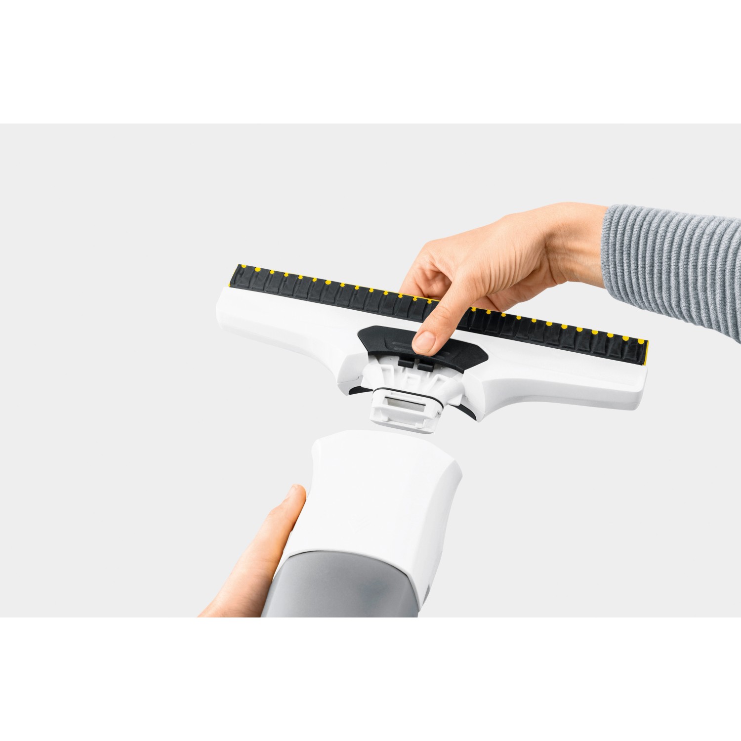 Kärcher Akku-Fenstersauger WV 6 Plus: Hand setzt Düse auf Gerät. Ideal für streifenfreie Fensterreinigung.