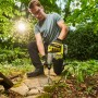 Mann arbeitet mit Ryobi Akku-SDS-Bohrhammer RSDS18BL-0 im Garten.