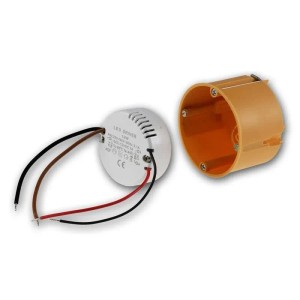 Runder, weißer 12W LED Transformator 12V DC mit Kabeln, neben orangefarbener Unterputzdose für Lampen.
