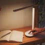 Weiße Philips LED-Tischleuchte Ivory mit Akku auf einem Schreibtisch mit Notizbuch.