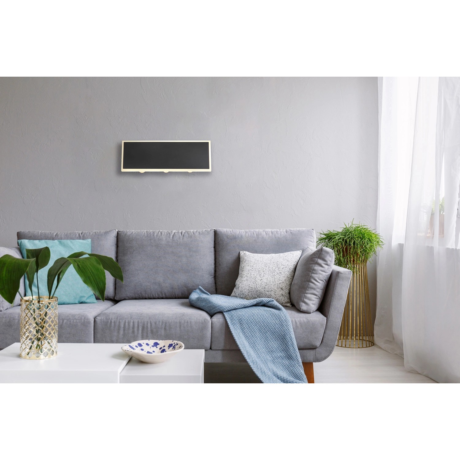 Moderne, schwarze LED-Wandleuchte Saidy, 25x9 cm, im Wohnraum über Sofa.