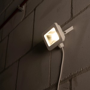 Weißer LED-Außenstrahler (10 W, 1100 lm, 4000 K) an einer grauen Wand.