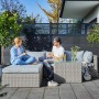 Lounge-Sessel Olea aus Polyrattan Sand mit Personen auf Terrasse. Gartenmöbel zum Entspannen.