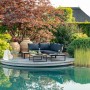 Greemotion Lounge-Set Rio, 3-teilig, Aluminium schwarz mit Akazienholz-Tisch auf einer Terrasse am Wasser.