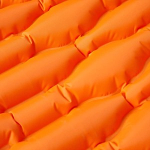Orangefarbene, selbstaufblasende Isomatte mit Kissen für Camping & Outdoor.