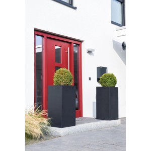 Zwei anthrazitfarbene Vivanno Pflanzkübel Block (40x40x80 cm) vor einem Hauseingang.