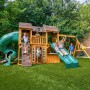 Zwerkules Spielturm Bolzo mit Rutschen, Schaukel und Kletterwand im Garten mit spielenden Kindern.