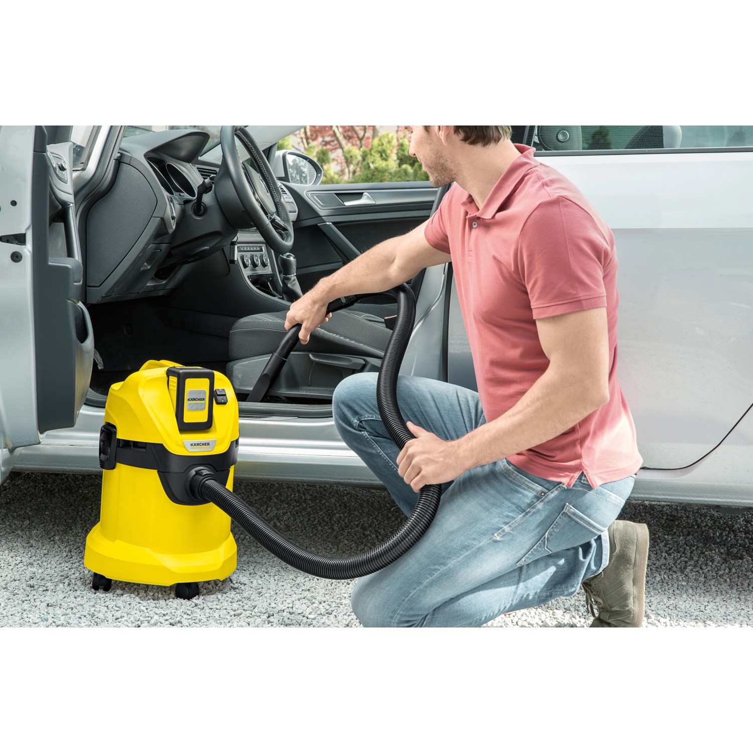 Gelber Kärcher Akku-Mehrzwecksauger WD 3 Battery im Einsatz zur Autoinnenraumreinigung.