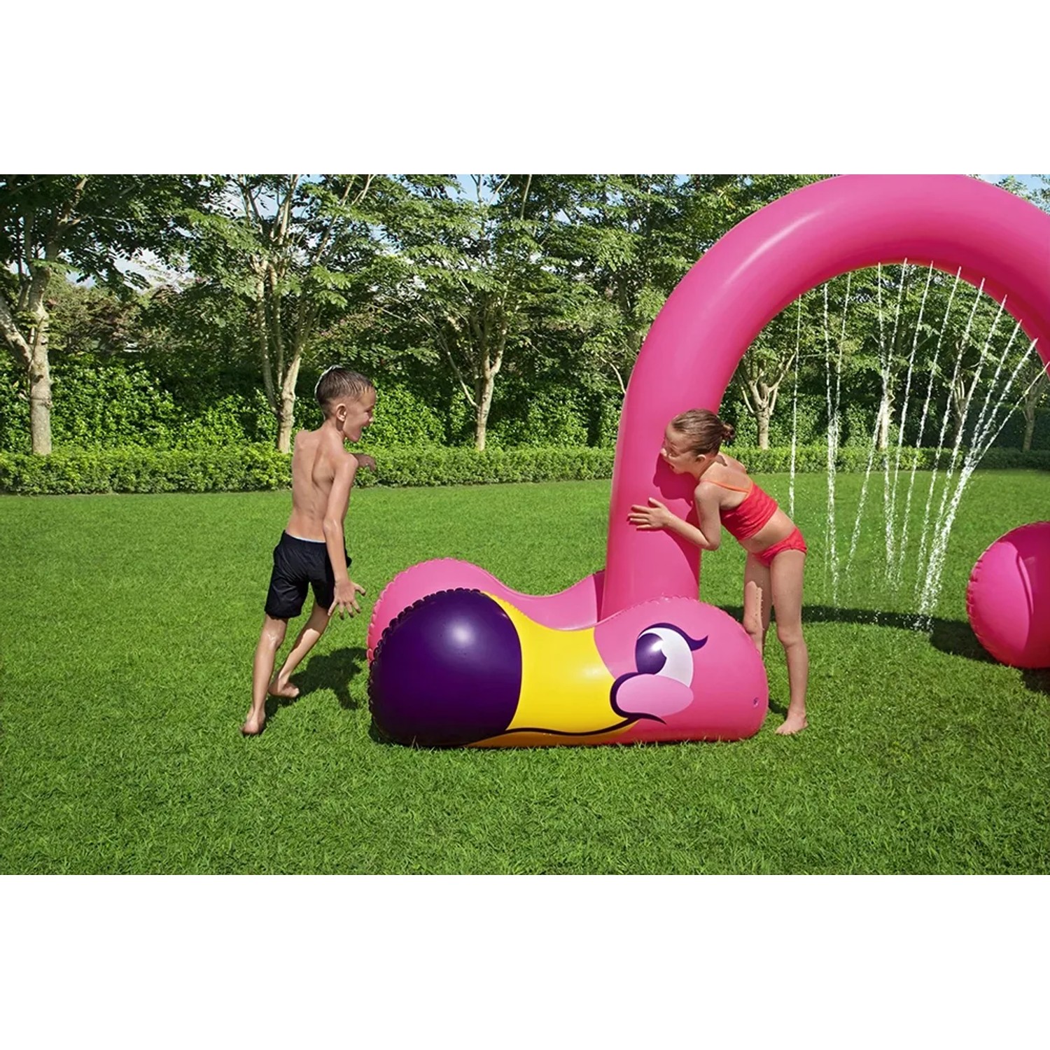 Bestway Jumbo Wassersprinkler Flamingo mit spielenden Kindern im Garten.