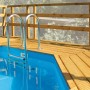 Weka Sonnendeck für Holzpool: Holzterrasse mit Leiter und Geländer am Pool.