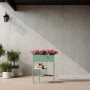 Vente-unique Hochbeet Alipial mandelgrün 60 cm mit pinken Blumen auf Terrasse, integrierte Ablagen.