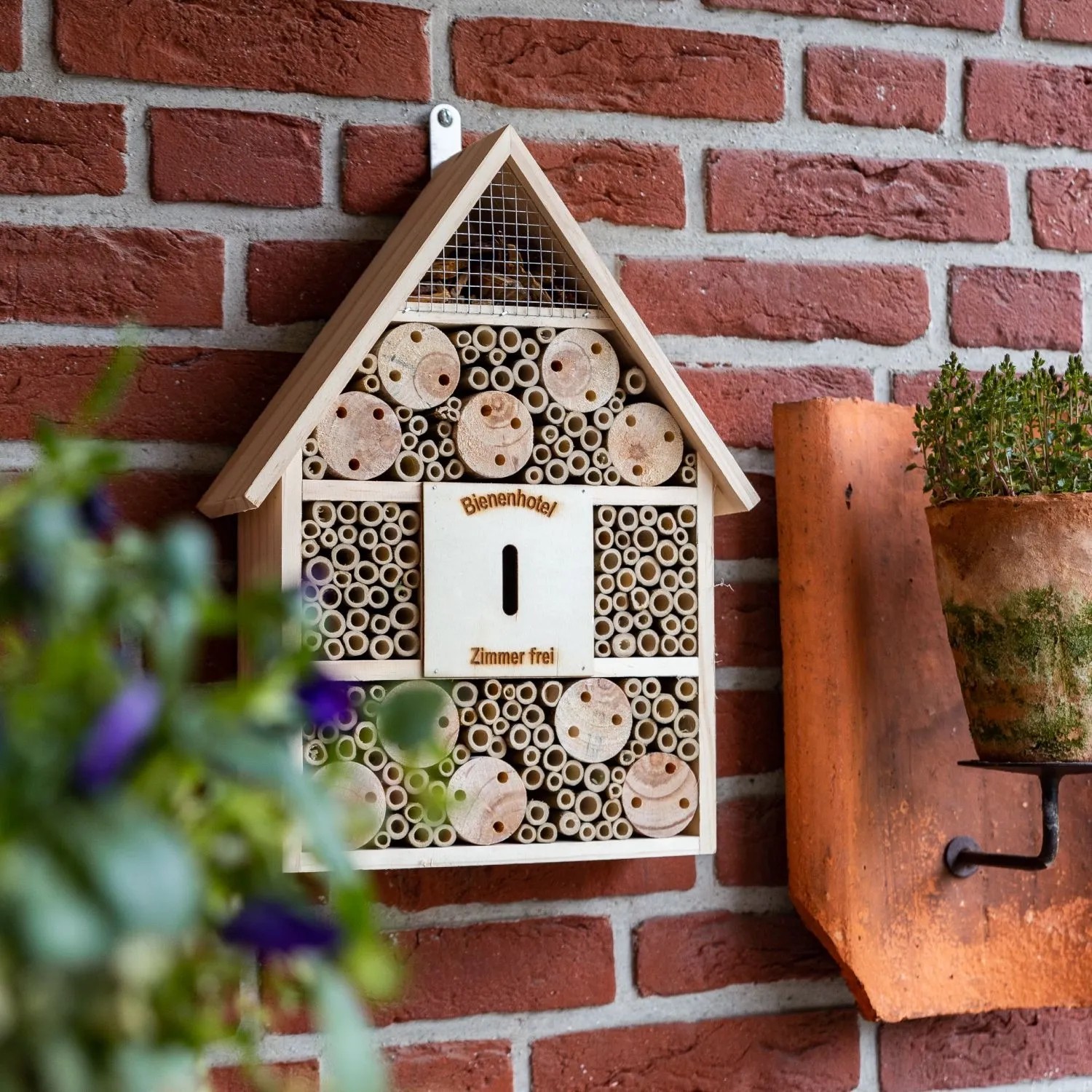 CULT at home Insektenhotel Braun, 41x28,5 cm, aus Holz mit Bambusröhrchen & Holzblöcken an Ziegelwand.