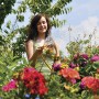 Frau bewässert Blumen mit Hozelock Bewässerungs-Set im Garten.