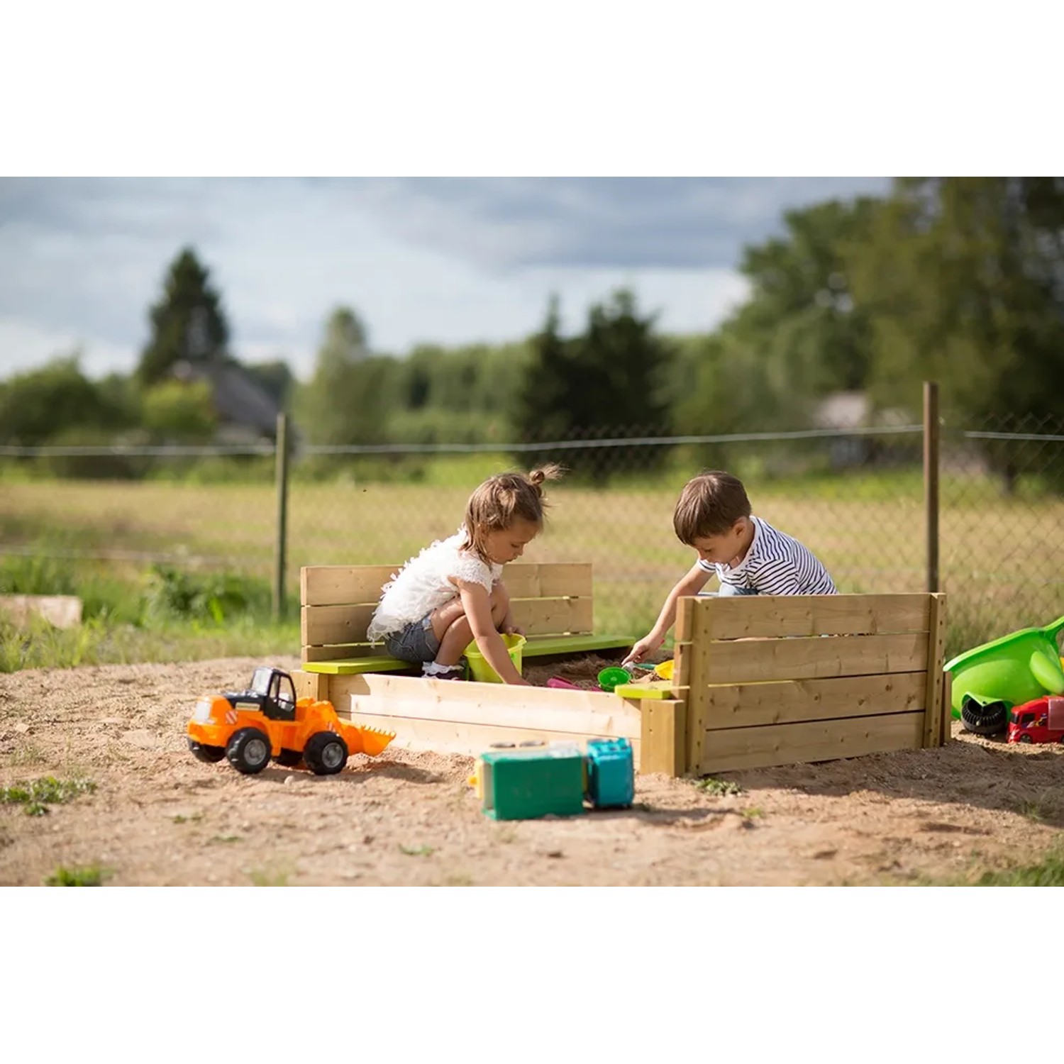 Wendi Toys Sandkasten mit Holzabdeckung und Sitzflächen, bespielt von Kindern im Garten.