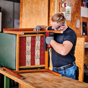 Handwerker mit Einhell Druckluftnagler TC-PN 50 beim Polstern eines Stuhls.